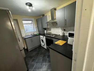 a kitchen with gray cabinets and a black counter top at Double bed BW3 Accrington Burnley in Accrington