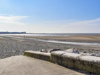 a beach with rocks on the sand and the ocean at Promenade - Uk48690 in Lancaster
