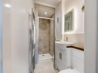 a white bathroom with a sink and a shower at Pier View - Uk48691 in Lancaster