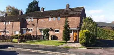 a large brick house with a black fence at Bright Double Room, Smart TV, Very Close to Train Station in Egerton