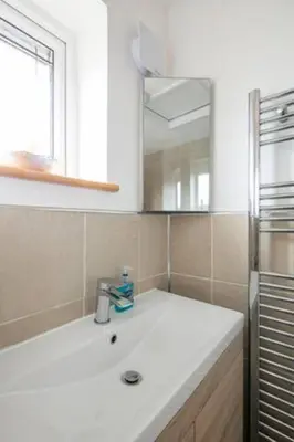 a white bathroom with a sink and a mirror at Bright Double Room, Smart TV, Very Close to Train Station in Egerton