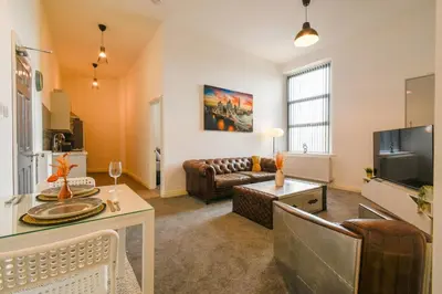 a living room with a couch and a table at Modern Suite Blackburn in Blackburn