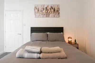 a bedroom with a bed with two towels on it at Modern Suite Blackburn in Blackburn