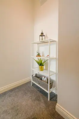 a white shelf with a plant in a room at Modern Suite Blackburn in Blackburn