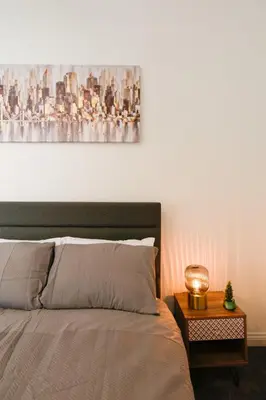 a bedroom with a bed with a painting on the wall at Modern Suite Blackburn in Blackburn