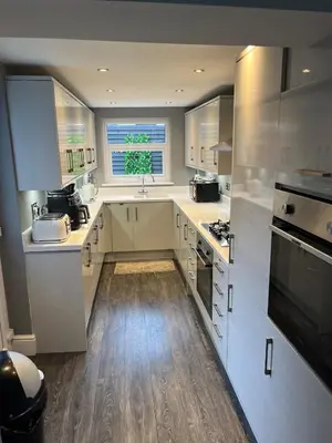 a kitchen with white cabinets and a sink and a window at Flat3 large modern king Bed flat private bathroom ryan's place in Walton on the Hill