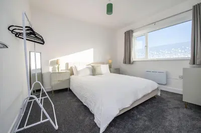 a white bedroom with a large bed and a window at Modern 3-Bed Home-Liverpool Stay in Sefton