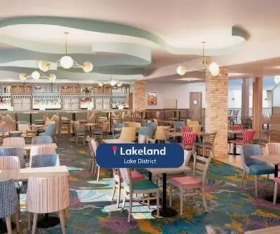 a restaurant with chairs and tables and a library at Miarlo Lodge Derwent Haven Lakeland in Grange Over Sands