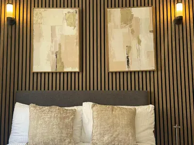 a bedroom with a bed with two pictures on the wall at Stylish city centre Penthouse in Liverpool