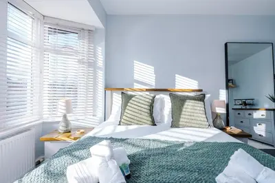 a bedroom with a bed and a large window at 4 Bed House Relocators Trades and long stays in Samlesbury