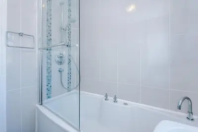 a bathroom with a shower and a tub and a sink at 4 Bed House Relocators Trades and long stays in Samlesbury