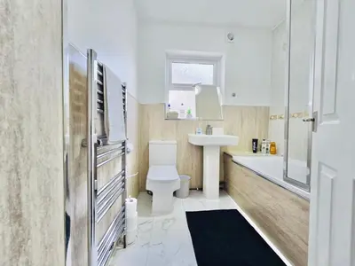 a bathroom with a toilet and a sink and a tub at Room 3 Shared House in Bootle in Litherland