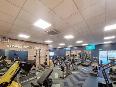 a gym with treadmills and machines in it at Tower Cottage in Arnside