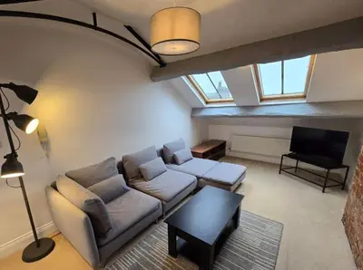 a living room with a couch and a table at Stylish City Centre Apartment With Parking in Preston