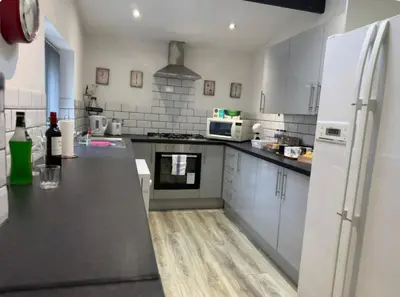 a kitchen with white appliances and a black counter top at Room 4 Shared House in L6 in Liverpool