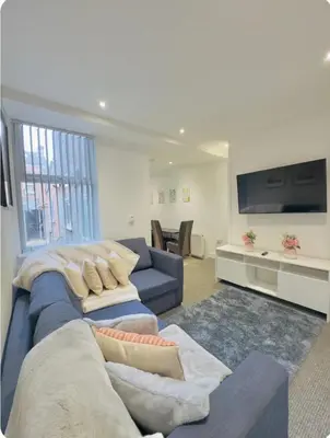 a living room with a blue couch and a tv at Room 6 Shared House in L6 in Liverpool