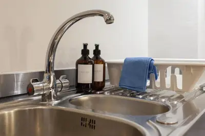 two bottles of wine sitting on a kitchen sink at Elegant City Retreat Contemporary 2BR 2BA Netflix Included in Liverpool