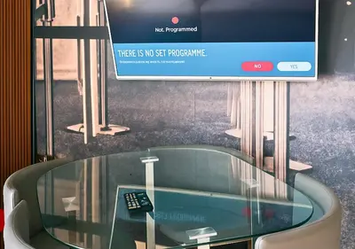 a tv screen with a glass table with a remote control at The Vault Liverpool City Centre sleeps 4 in Liverpool