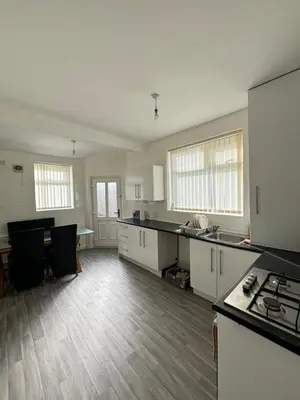 an empty kitchen with white cabinets and a table at Affordable room near Anfield stadium - 5 minute walk in Liverpool