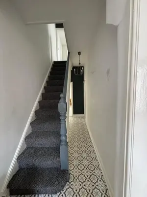 a stairway with a blue rail and a black door at Affordable room near Anfield stadium - 5 minute walk in Liverpool