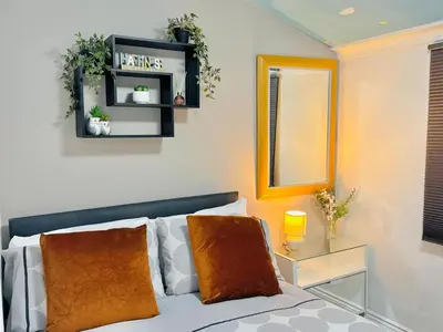 a living room with a bed and a mirror at Room 2 Shared House in Bootle in Litherland