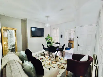 a living room with a couch and a table and chairs at Room 2 Shared House in Bootle in Litherland