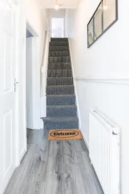 a staircase with a welcome mat on the floor at Contractors House with Parking City Area, sleeps 8 in Liverpool
