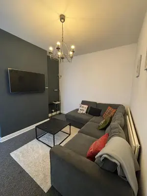 a living room with a couch and a flat screen tv at Room in Anfield 5 minute walk to stadium in Liverpool