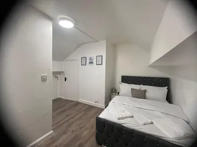 a bedroom with a large bed with a black headboard at Excellent Suite Room in Liverpool in Liverpool