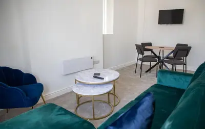 a living room with a couch and a table and chairs at Balmoral Stays 4 - First Floor in Blackpool