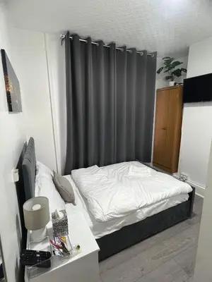 a small bedroom with a bed with a gray curtain at Sleeps 10- Free Parking- Close To Goodison&Anfield in Liverpool