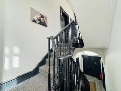 a hallway with a spiral staircase with a black railing at Pembroke Place Private room 5 in Liverpool