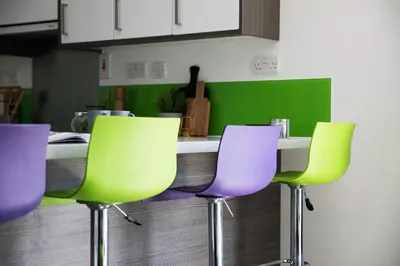 a kitchen with green and purple chairs and a counter at Student Only Ensuite at Prospect Point Liverpool in Liverpool
