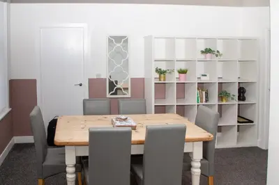 a dining room with a wooden table and chairs at Santiago Suites in Southport