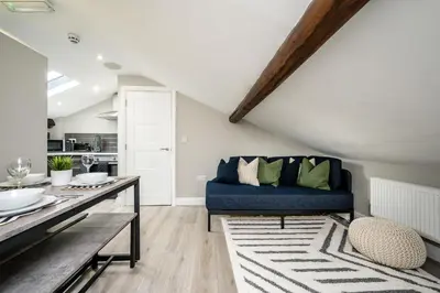 a living room with a blue couch and a table at Two Apartments in One , City Centre, Sleeps 11! in Liverpool