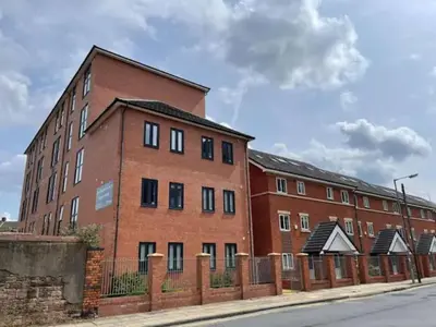 a brick building with a fence in front of it at Spacious 13 Bedroom Apartment in Liverpool in Liverpool