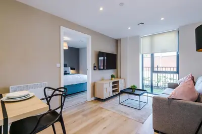 a living room with a couch and a table and a bed at High End 2 Bedroom with Parking and City Access in Liverpool