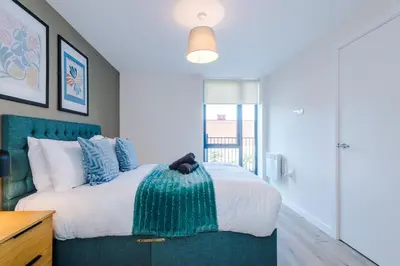 a bedroom with a large bed with blue accents at High End 2 Bedroom with Parking and City Access in Liverpool
