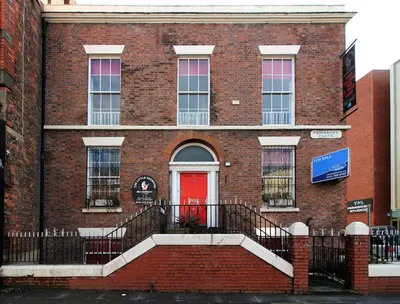 a red brick building with a red door at Pembroke Place Private Room 9 in Liverpool