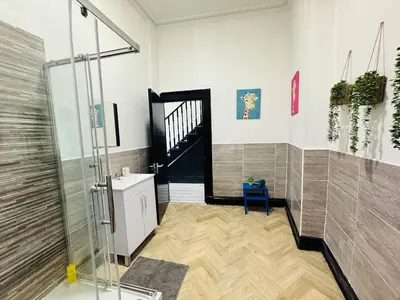 a bathroom with a shower and a blue chair at Pembroke Place Private Room 4 in Liverpool