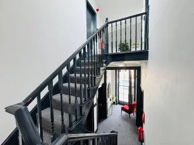 a staircase in a house with a red chair at Pembroke Place Private Room 4 in Liverpool