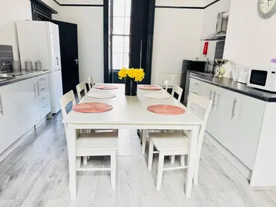 a white kitchen with a white table and chairs at Pembroke Place Private Room 7 in Liverpool