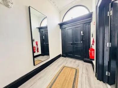a hallway with two black doors and a mirror at Pembroke Place Private Room 10 in Liverpool