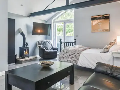 a living room with a bed and a fireplace at Madeline Cottage in Clitheroe