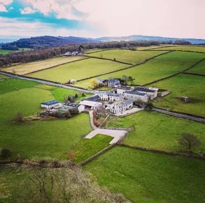 an aerial view of a large house in a field at The Old Farmhouse, Yealand Redmayne, a characterful cottage in a rural setting in Beetham