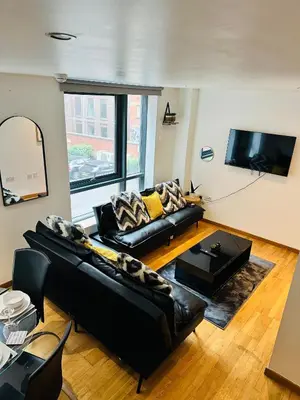 a living room with black leather furniture and a flat screen tv at 2 Bedroom City Centre Apartment Free Secure Parking in Liverpool