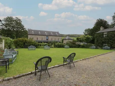 a group of chairs sitting on a lawn in front of a building at The Old Kitchen in Grange Over Sands