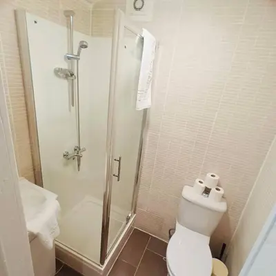 a white bathroom with a shower and a toilet at Bold Street Studio III in Liverpool