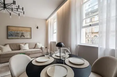a living room with a table and chairs and a couch at Sunnie stays apartment harrington chambers in Liverpool