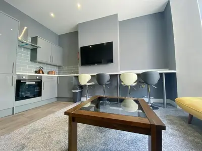a living room with a coffee table and a tv at Full Private House Sleeping Up To 18 - Close To Seafront in Blackpool
